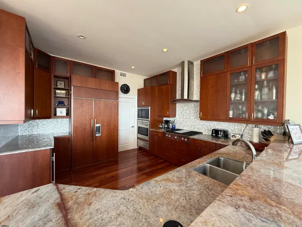 a large kitchen with granite countertop a refrigerator and a sink