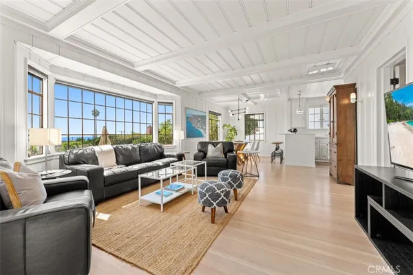 a living room with furniture a wooden floor and next to a window