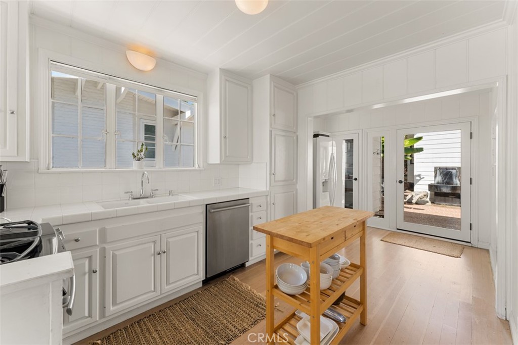 500 Mountain Road Laguna Beach, CA 92651 - Photo 10 of 36 a large white kitchen with granite countertop a sink and dishwasher a stove with wooden floor