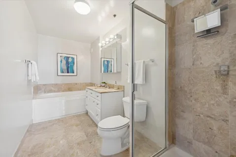 a bathroom with a granite countertop toilet a sink and bathtub