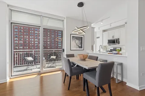 a dining room with furniture a chandelier and wooden floor