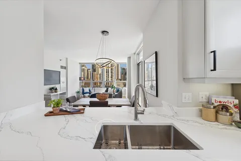 a kitchen with kitchen island granite countertop a sink chairs and cabinets
