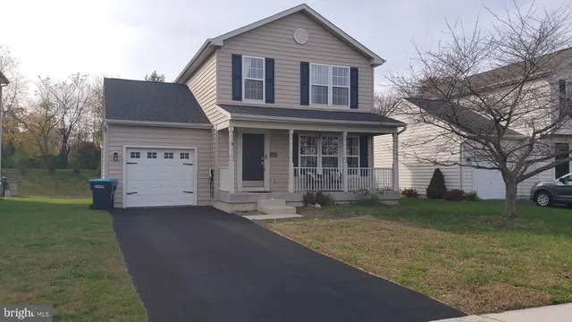 a front view of a house with a garden and trees