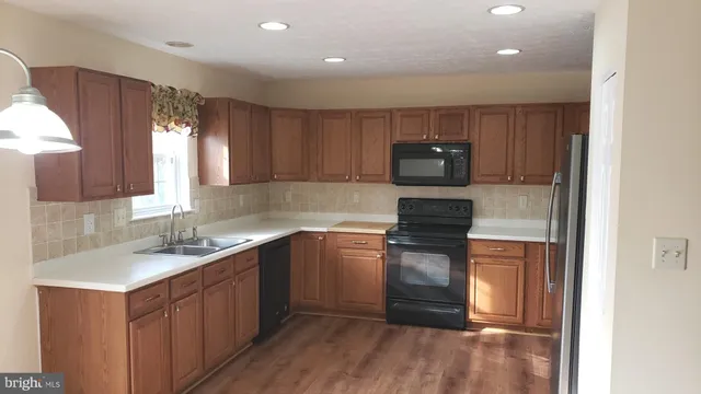 a kitchen with sink a microwave and cabinets