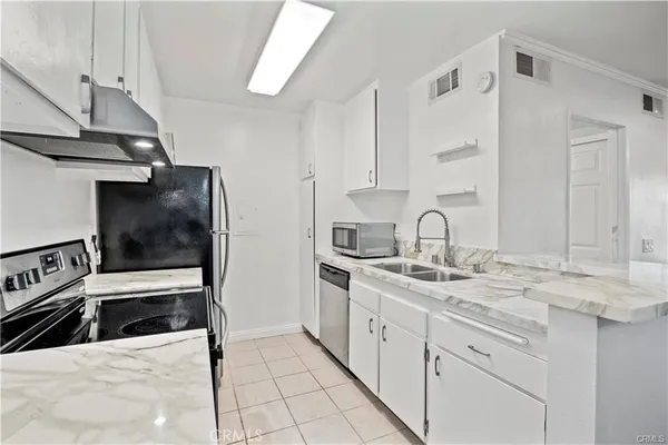 a kitchen with stainless steel appliances kitchen island granite countertop a sink and a stove