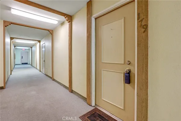 a view of a hallway with wooden floor and closet