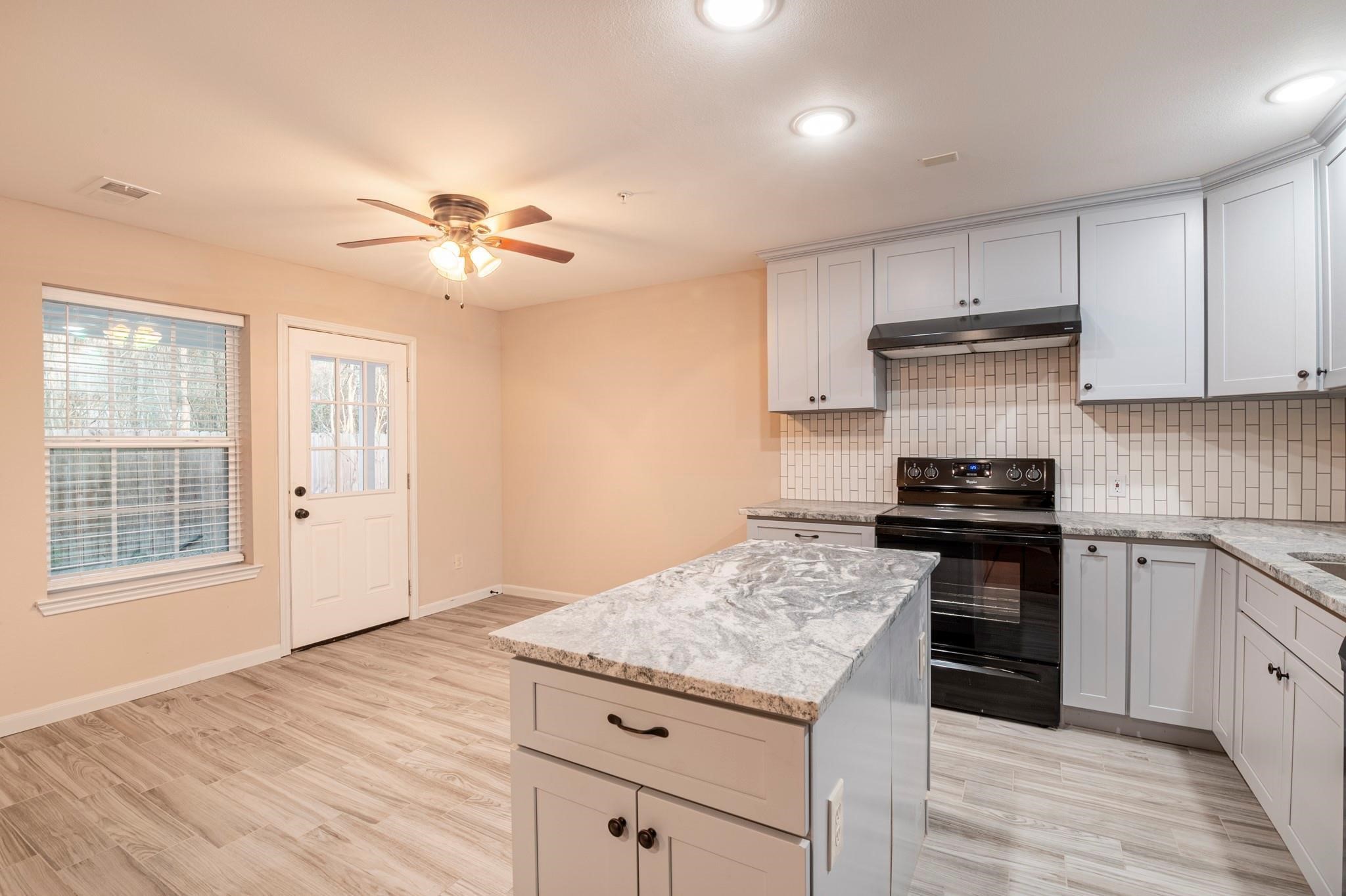 22262 Adams Street, Unit 9 Porter, TX 77365 - Photo 5 of 11 a kitchen with a stove a sink and a refrigerator