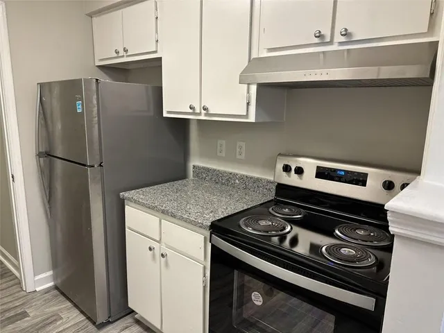 a view of a hallway with wooden floor and a chandelier