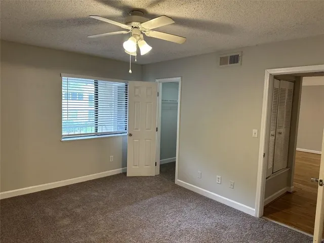 an empty room with a ceiling fan and a window