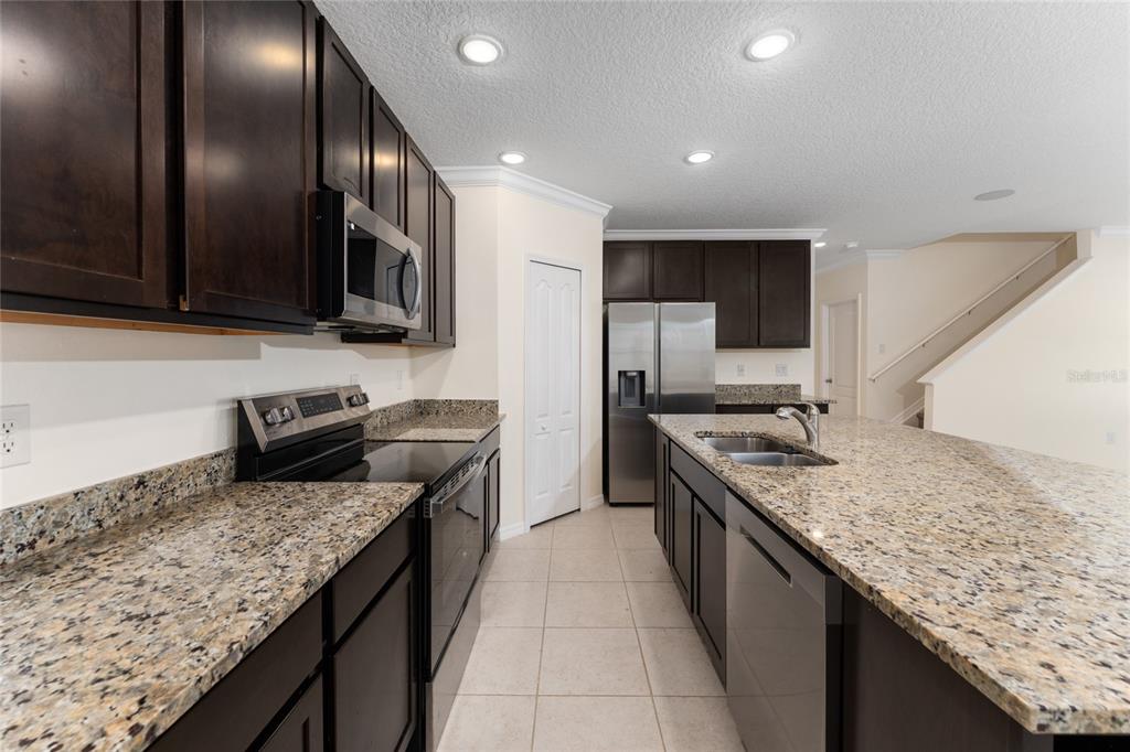 4331 Wayne Road Fruitland Park, FL 34731 - Photo 17 of 46 a kitchen with granite countertop stainless steel appliances and wooden cabinets
