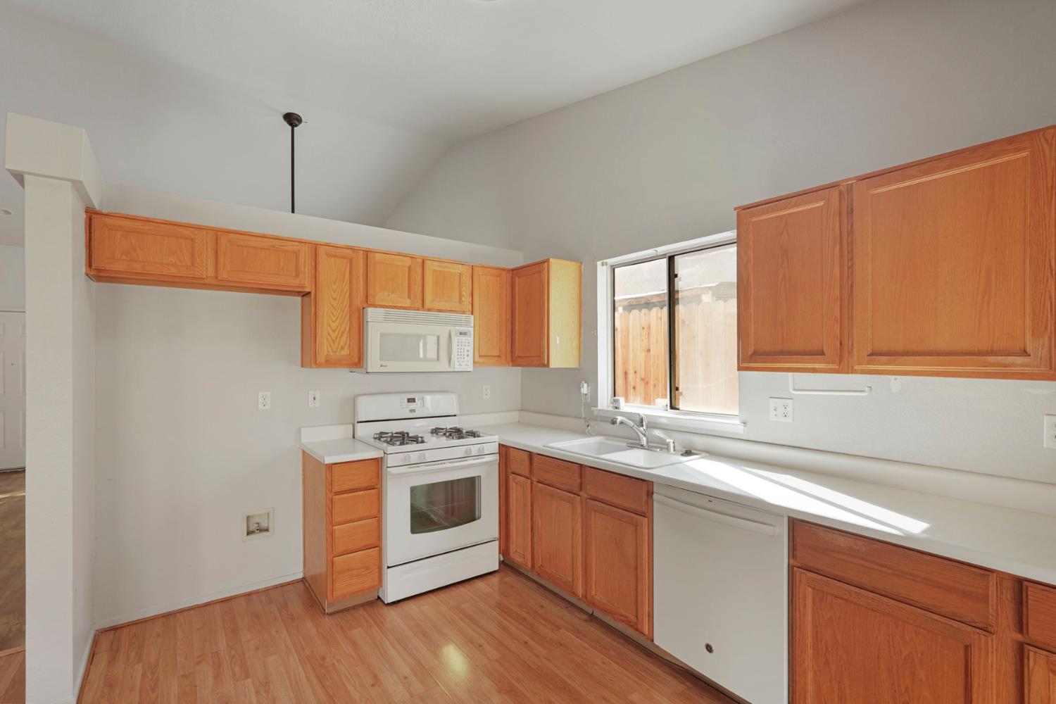 2449 Calvert Street Stockton, CA 95210 - Photo 12 of 37 a kitchen with stainless steel appliances granite countertop a sink a stove a refrigerator wooden floor and cabinets