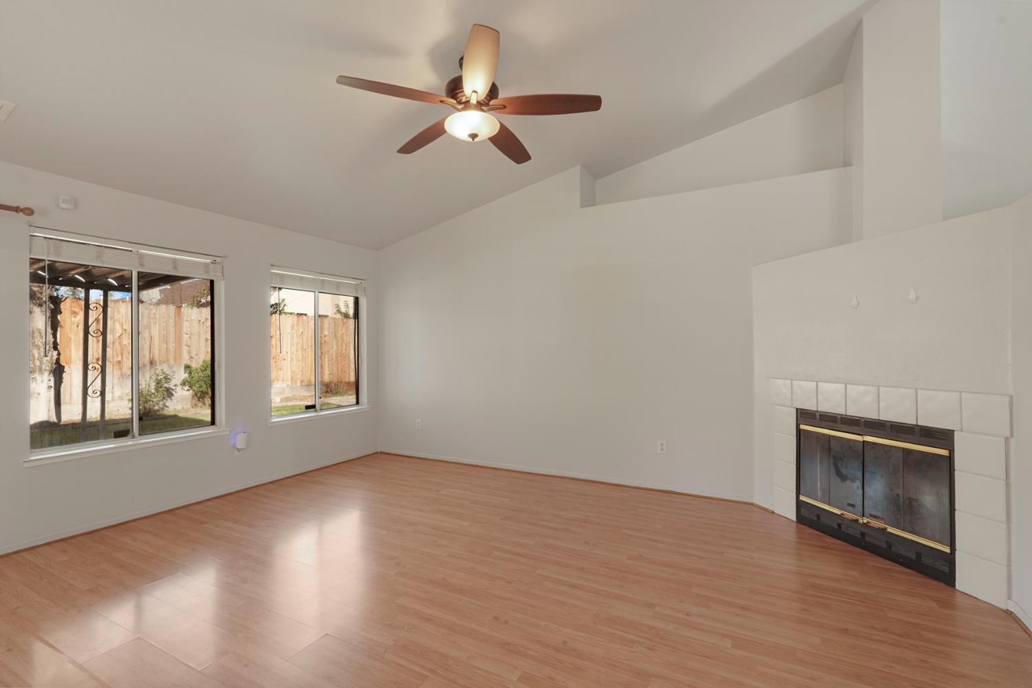 2449 Calvert Street Stockton, CA 95210 - Photo 15 of 37 an empty room with wooden floor fan and windows