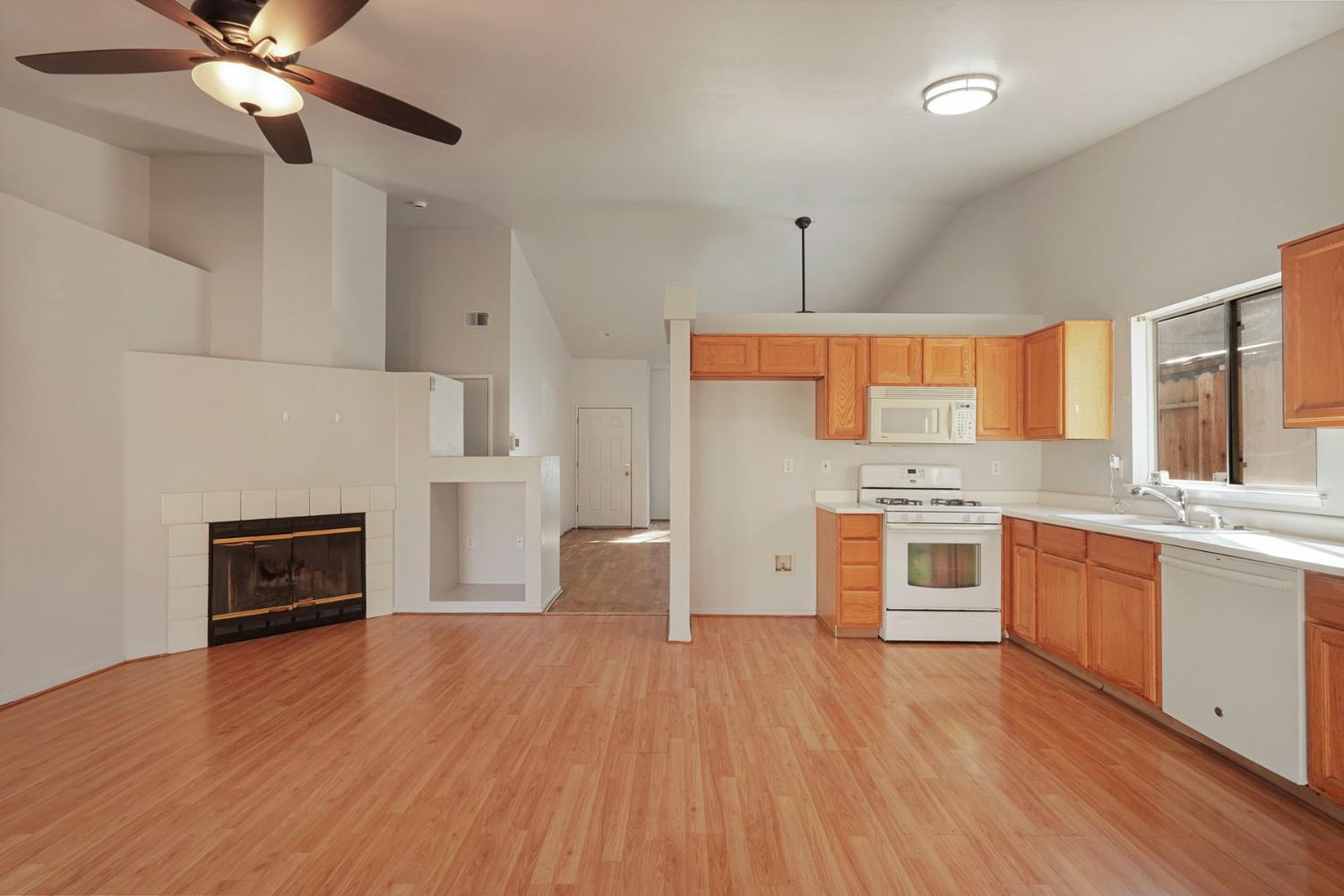 2449 Calvert Street Stockton, CA 95210 - Photo 18 of 37 a large kitchen with granite countertop a stove top oven a sink dishwasher and a fireplace with wooden floor