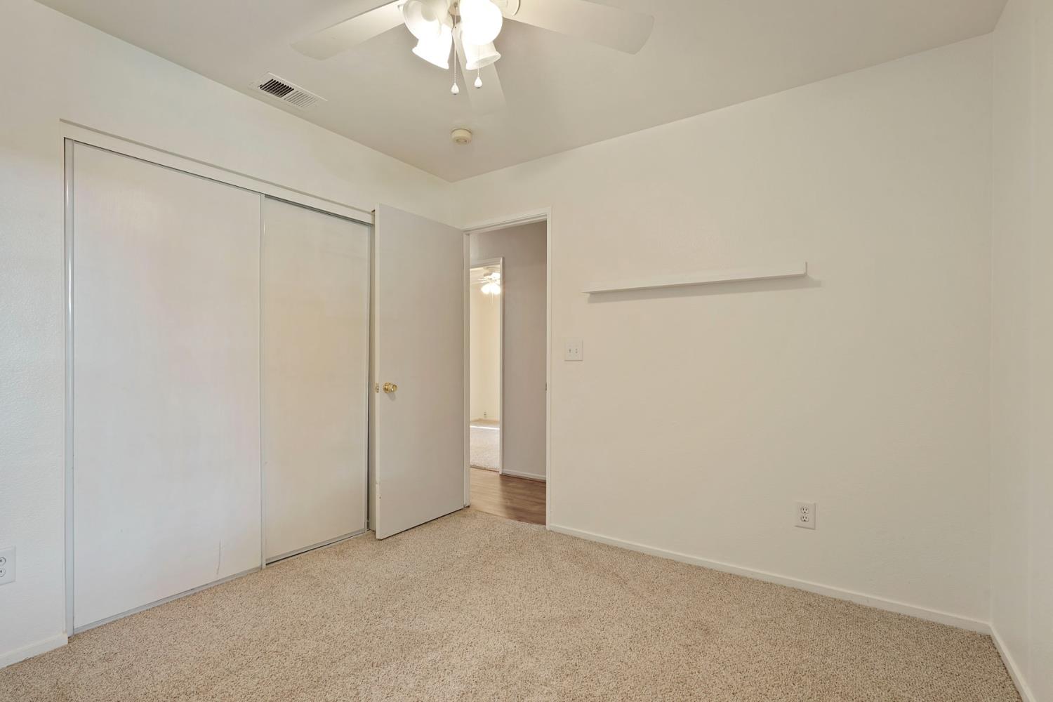 2449 Calvert Street Stockton, CA 95210 - Photo 23 of 37 an empty room with a chandelier fan
