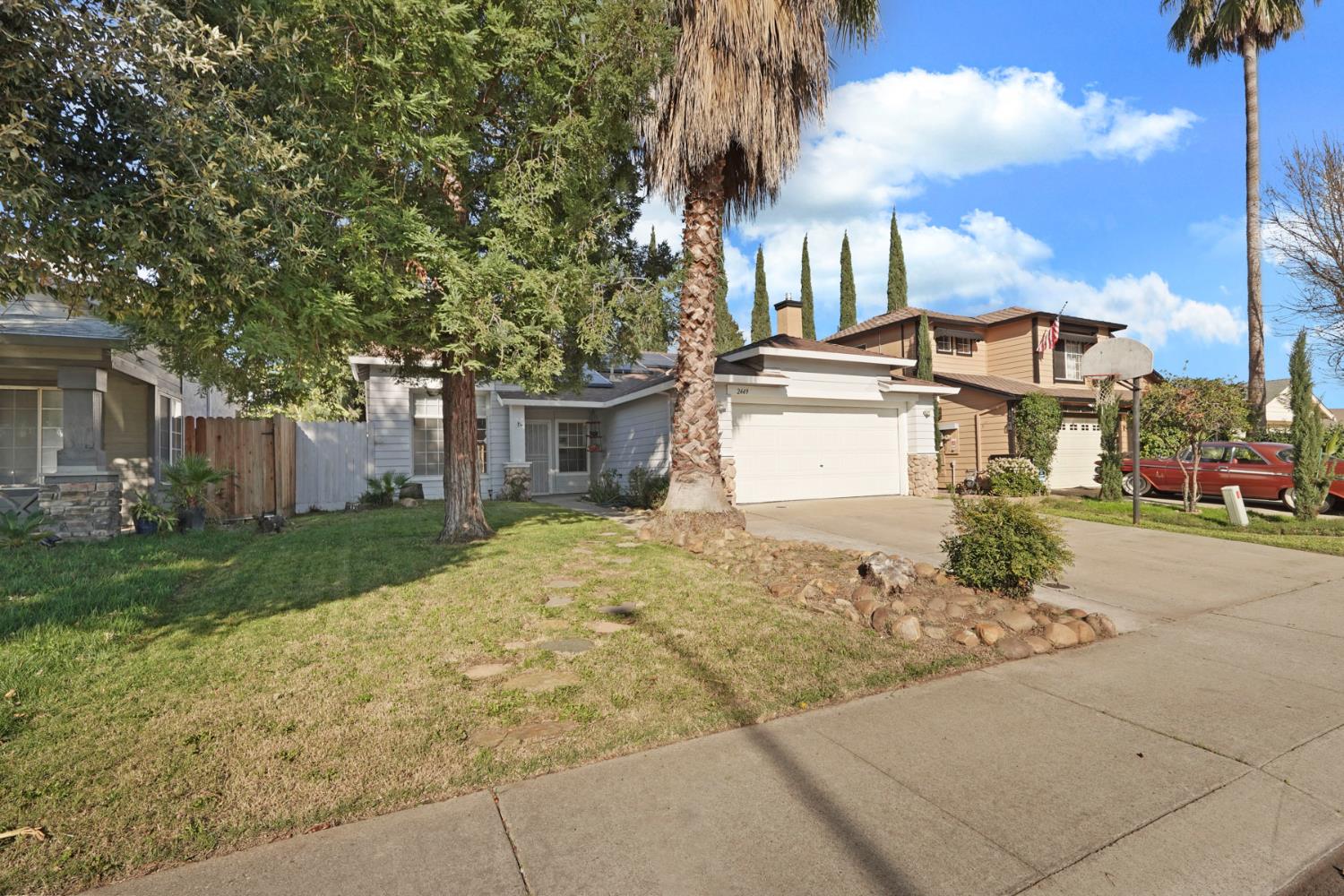 2449 Calvert Street Stockton, CA 95210 - Photo 5 of 37 a front view of a house with a yard and garage