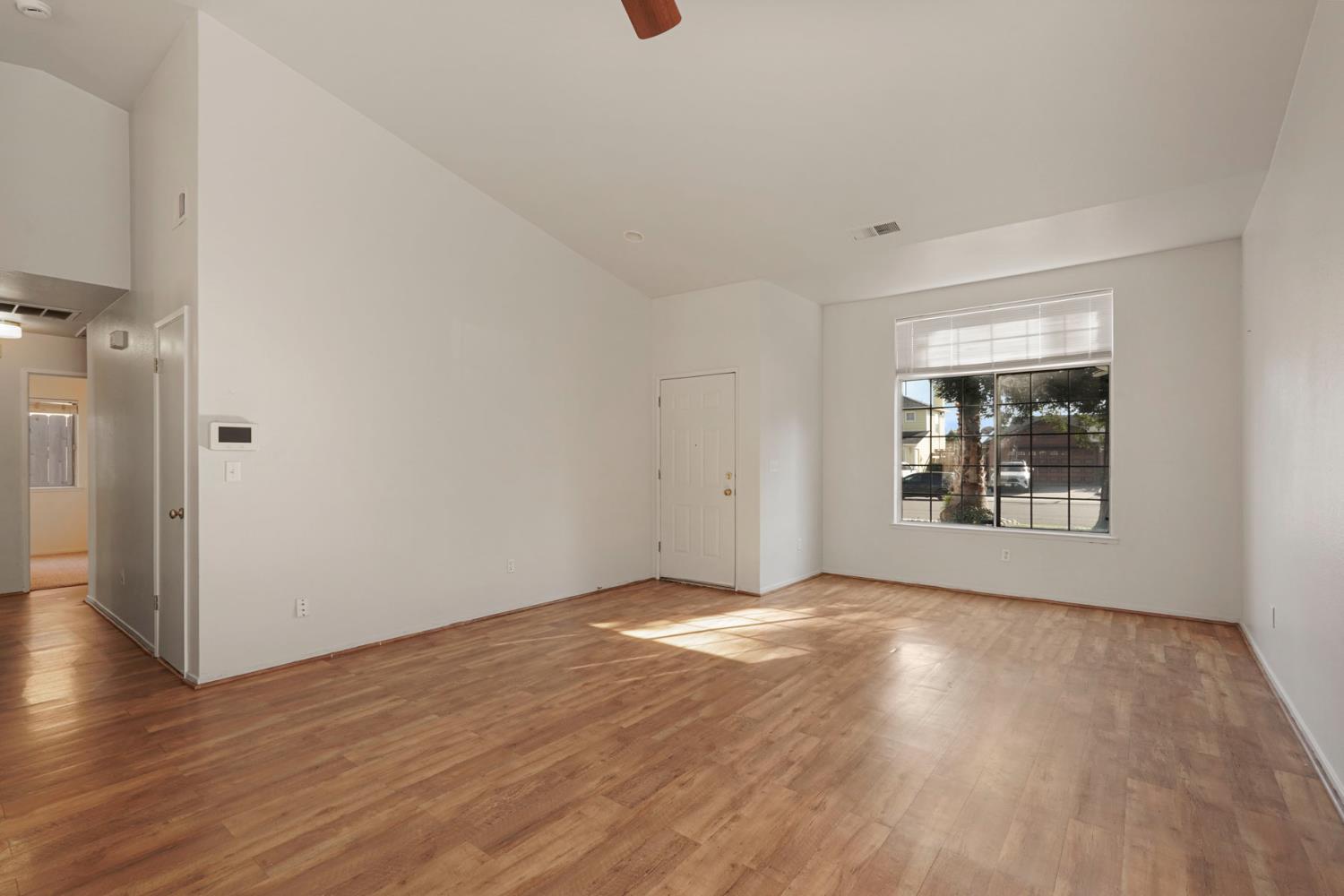 2449 Calvert Street Stockton, CA 95210 - Photo 8 of 37 a view of an empty room with wooden floor and a window