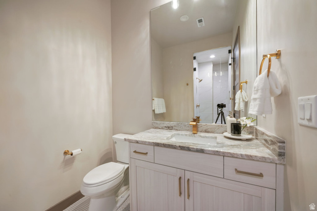 10646 North Reflection Ridge Hideout, UT 84036 - Photo 24 of 43 White vanity with gold hardware, integrated rectangular sink, and stone-finish countertop with matching backsplash