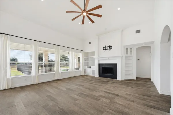 a view of a livingroom with a fireplace and a chandelier fan