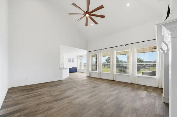 a view of a livingroom with a fireplace a ceiling fan a fireplace and windows