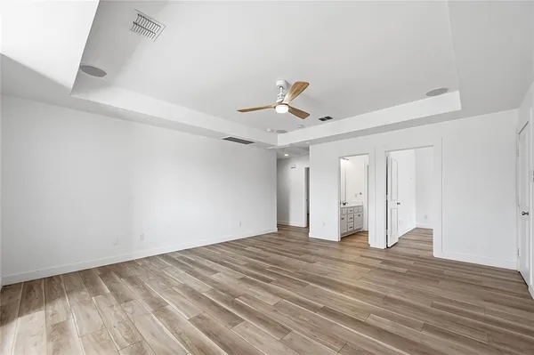 a view of an empty room with wooden floor