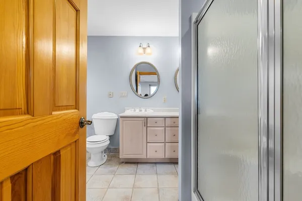 a bathroom with a toilet a sink and mirror