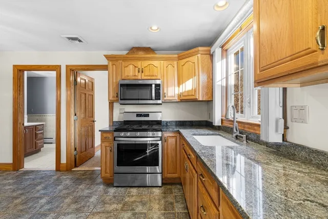 a kitchen with stainless steel appliances granite countertop a refrigerator and a stove top oven
