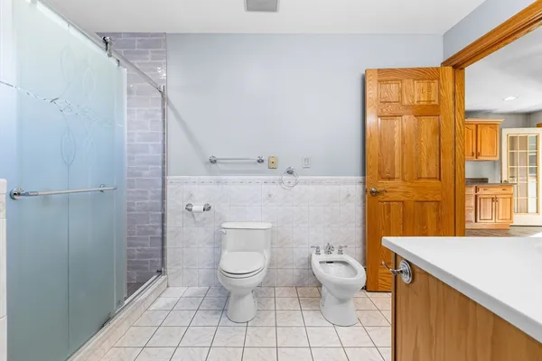 a bathroom with a granite countertop toilet a sink and a shower