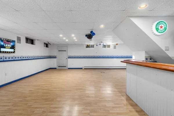 a view of kitchen with stainless steel appliances wooden floor and window