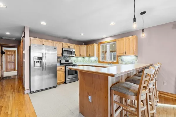 a kitchen with stainless steel appliances granite countertop a refrigerator and a stove top oven