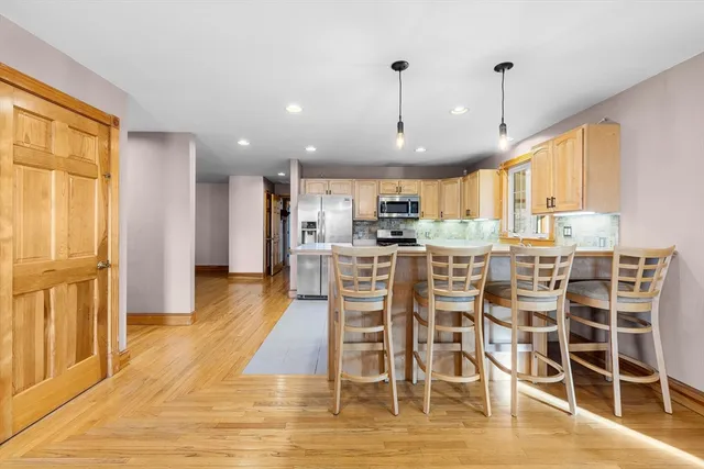 a view of a kitchen with dining space wooden floor and windows