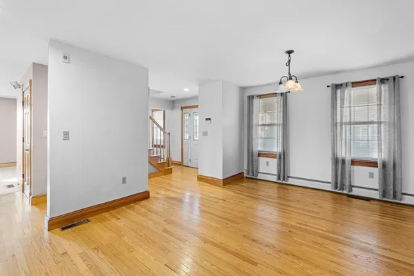 a view of an empty room with window and wooden floor