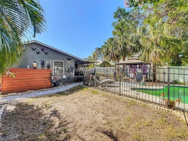 a view of house with backyard and sitting area