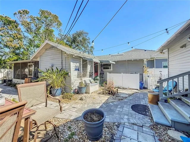 a view of a patio with table and chairs potted plants and wooden fence
