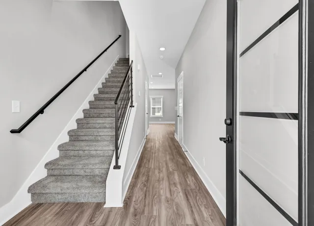 a view of a hallway with wooden floor and staircase