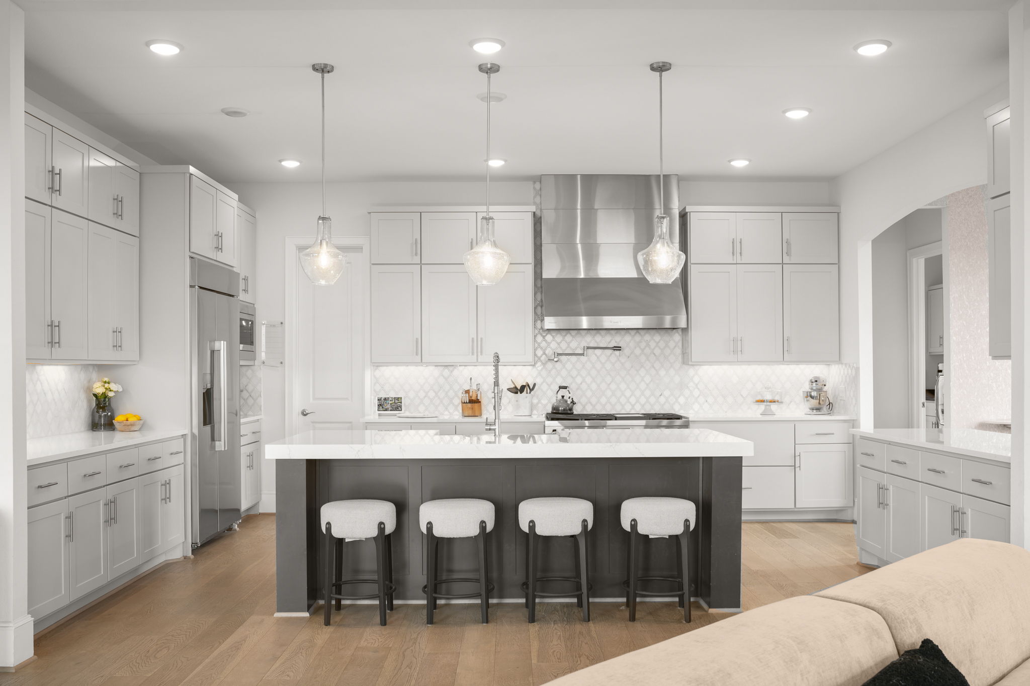 104 Lodestone Cove Austin, TX 78738 - Photo 4 of 40 Culinary aspirations come alive in this kitchen, featuring an expansive island, bright lighting, and hardwood flooring.