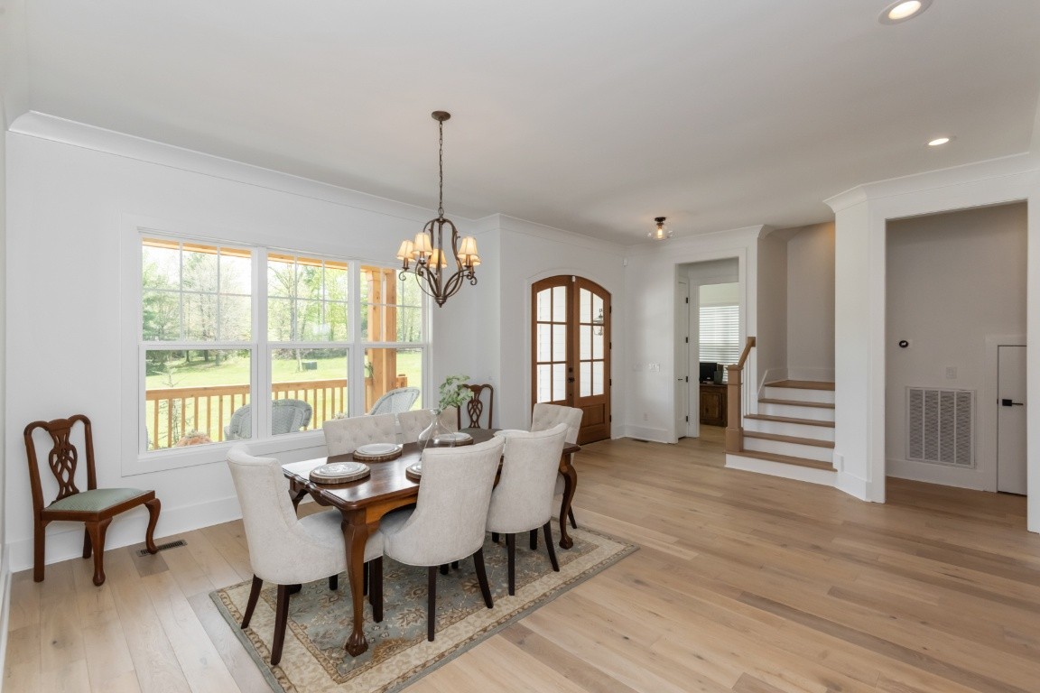 6926 Cairo Bend Road Lebanon, TN 37087 - Photo 5 of 42 a view of a dining room with furniture a chandelier and wooden floor