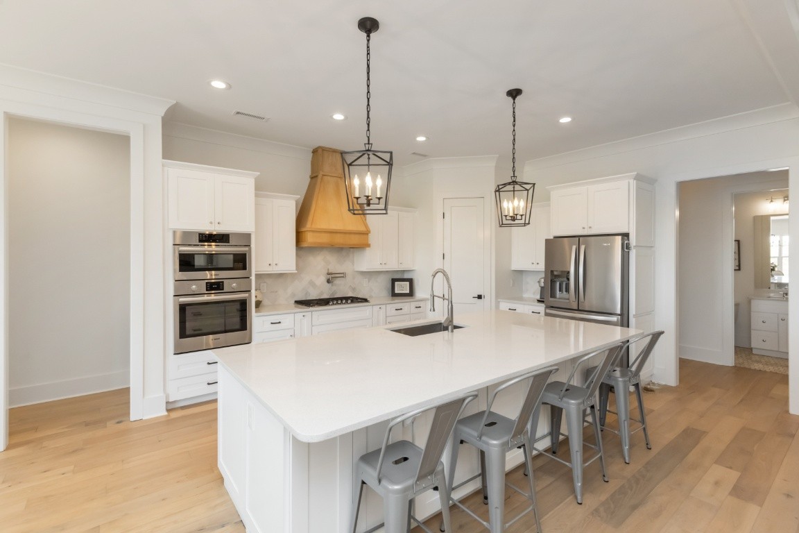 6926 Cairo Bend Road Lebanon, TN 37087 - Photo 10 of 42 a kitchen with stainless steel appliances kitchen island granite countertop a sink a stove a refrigerator and island with wooden floor