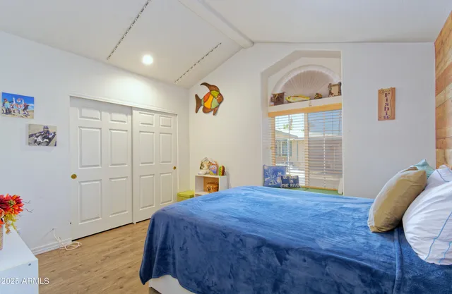 a bedroom with a bed and wooden floor