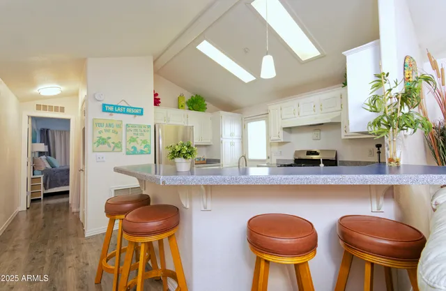 a kitchen with stainless steel appliances a table and chairs in it