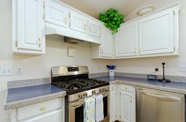a kitchen with white cabinets and appliances