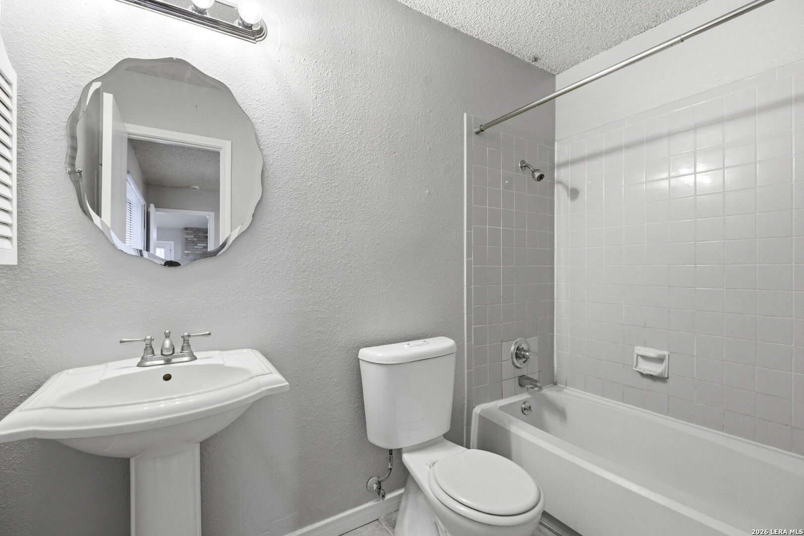 9439 Charter Point San Antonio, TX 78250 - Photo 10 of 14 a bathroom with a toilet sink and mirror