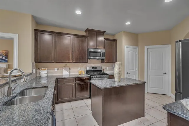 a kitchen with stainless steel appliances granite countertop a sink stove and refrigerator