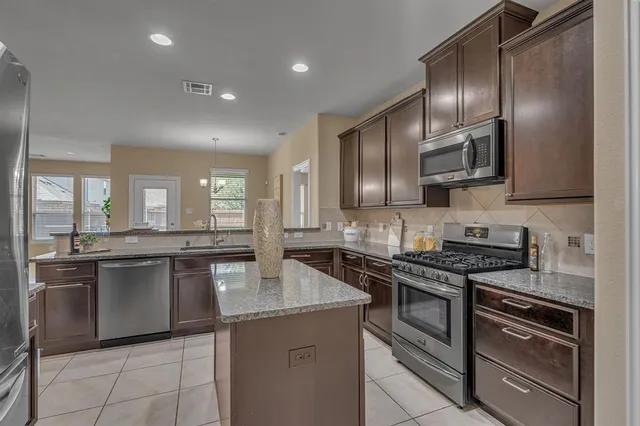 a kitchen with stainless steel appliances granite countertop a sink stove oven and cabinets