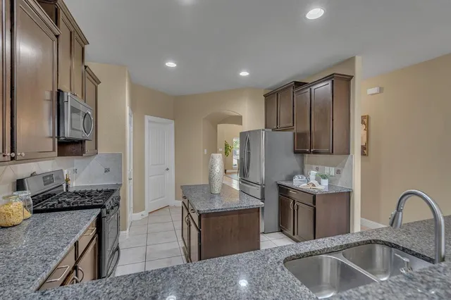 a kitchen with stainless steel appliances granite countertop a sink stove and refrigerator