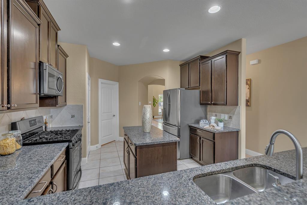 3812 Fordham Street Frisco, TX 75036 - Photo 15 of 33 a kitchen with stainless steel appliances granite countertop a sink stove and refrigerator