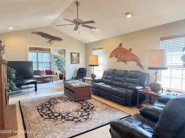 a kitchen with stainless steel appliances granite countertop a stove top oven a sink dishwasher and white cabinets with wooden floor