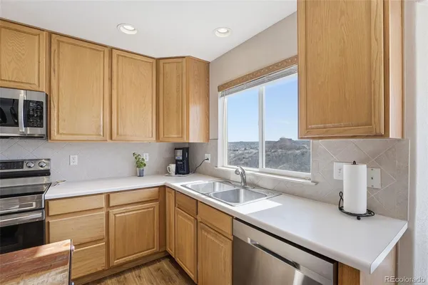 a kitchen with stainless steel appliances granite countertop a sink a stove and cabinets