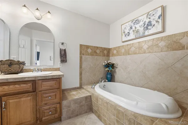 a bathroom with a tub sink and mirror