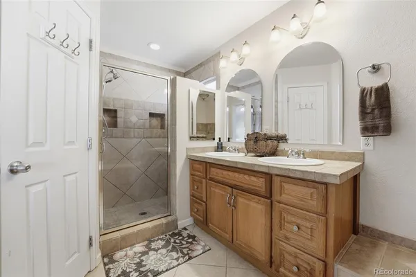 a bathroom with a double vanity sink mirror and shower