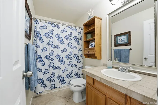 a bathroom with a granite countertop sink a toilet and a mirror